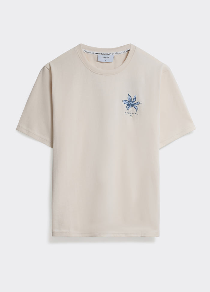 The Percival Flora T Shirt in off white, a cotton jersey crew neck featuring a blue floral graphic on the chest.