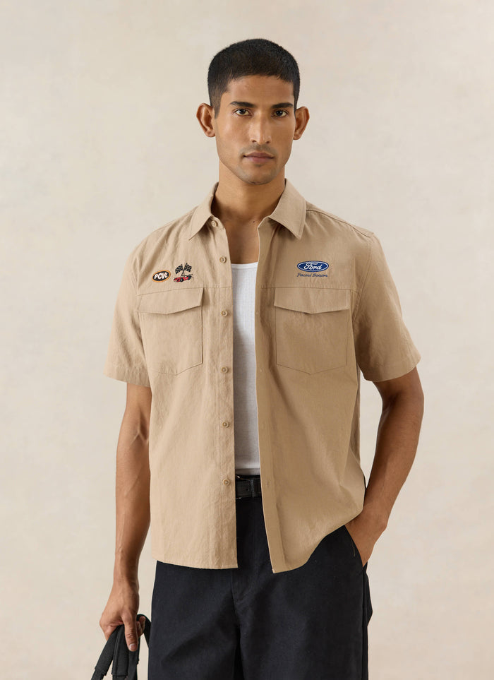 Beige Percival x Ford Miles Garage Shirt featuring twin chest pockets and vintage motorsport-inspired embroidery.