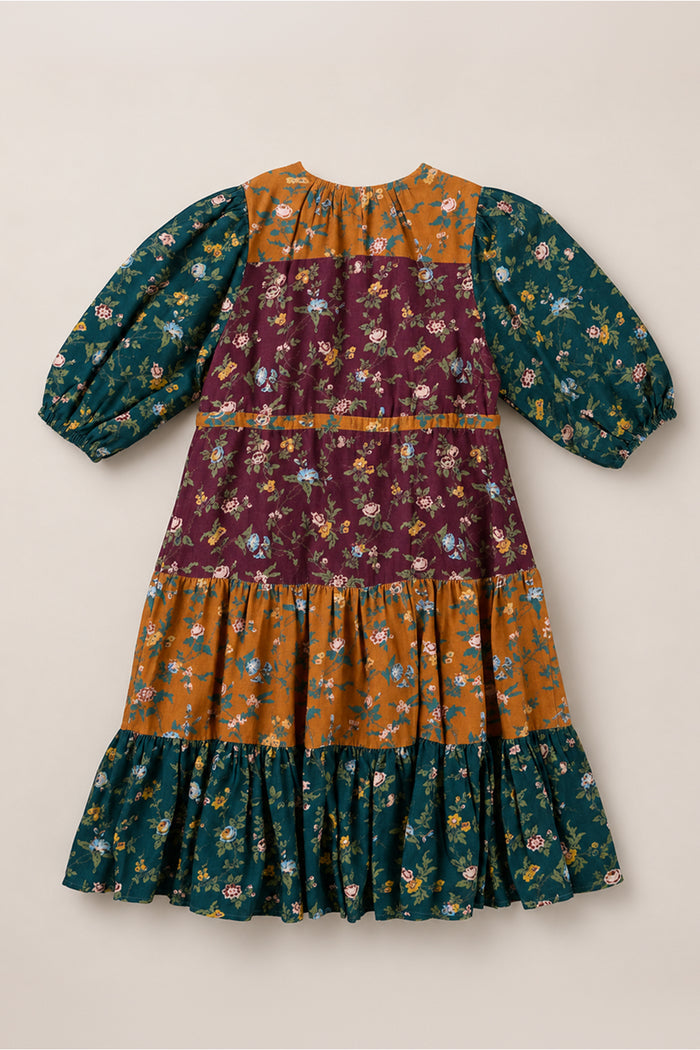 The Mini Harlowe Dress in Elysian Vine by Ivy City Co is a long-sleeve, tiered midi dress adorned with mixed floral prints in mustard yellow, burgundy, and forest green. Featuring stylish puff sleeves and a ruffle hem, this dress is crafted from soft viscose fabric and offers a loose fit for effortless comfort and elegance.