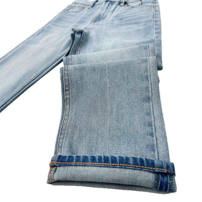 Folded light blue jeans on a white background