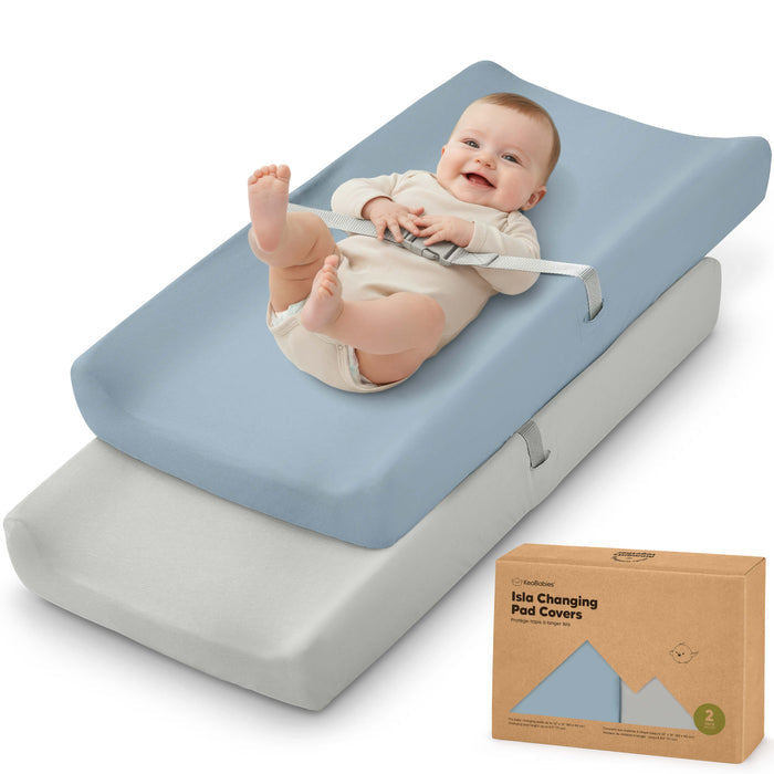 Isla changing pad covers, 2-pack, shown with a baby lying on top of the padded changing mat.