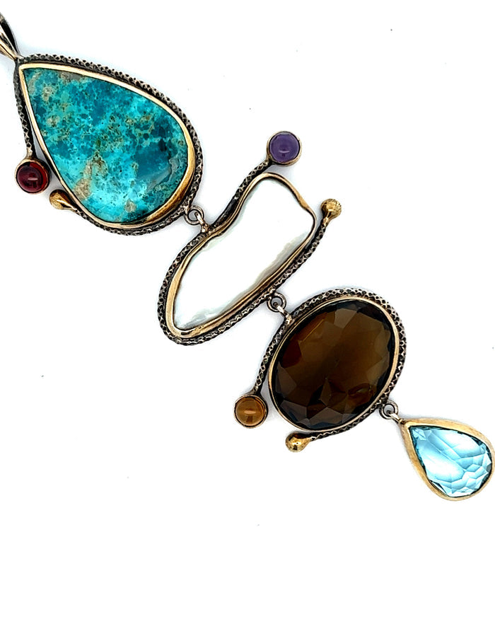 A four-tier pendant necklace with turquoise, pearls, and mixed gemstones in a cascading statement design.