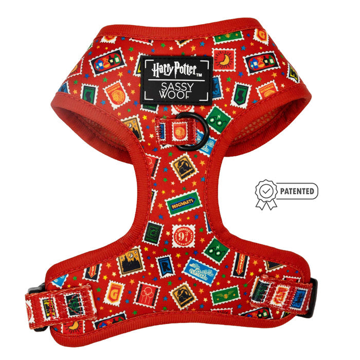 The Sassy Woof Dog Adjustable Harness – Harry Potter™ Stamps is a red harness with magical stamp designs, adjustable straps, and a patented side icon, featuring Harry Potter and Sassy Woof logos.