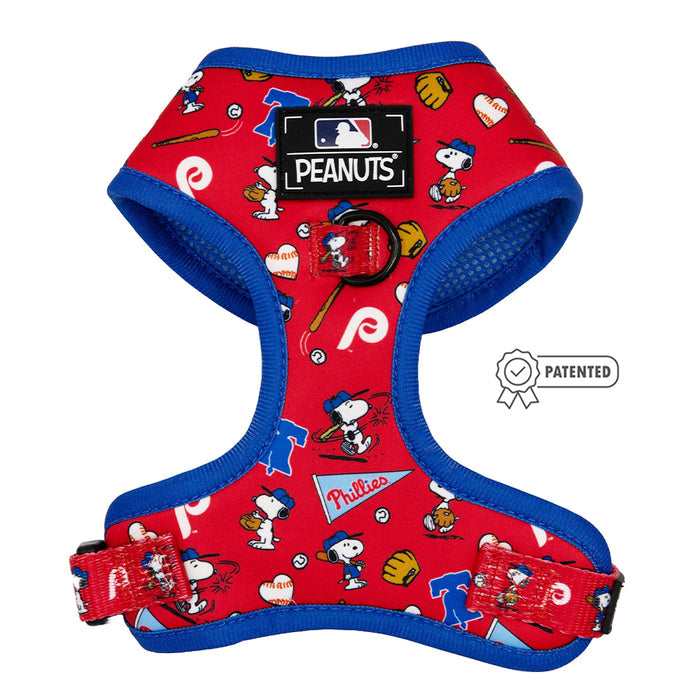 The Sassy Woof Dog Adjustable Harness - MLB™ x Peanuts™ Philadelphia Phillies™ features red fabric with blue trim, Peanuts characters, baseball gear, Phillies logos, an official PEANUTS MLB patch, and a patented symbol.
