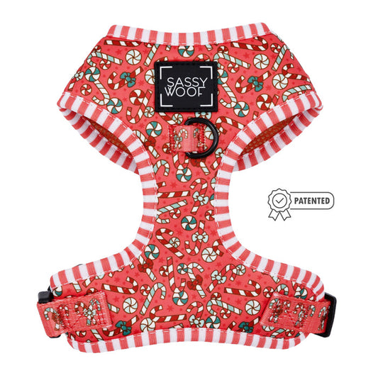 The Sassy Woof Dog Adjustable Harness - Puppermint Twist features red and white striped edges, candy cane and peppermint designs, a “Sassy Woof” label, and patented icon—perfect as a festive holiday harness for your pup.