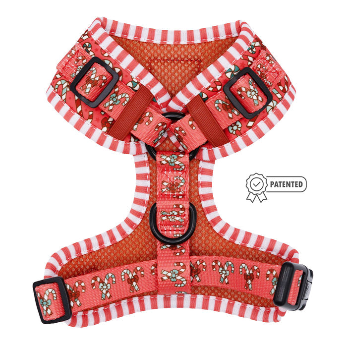 The Sassy Woof Dog Adjustable Harness - Puppermint Twist features red and white stripes with candy cane and holly patterns, black buckles, adjustment rings, and a PATENTED badge displayed on the right.