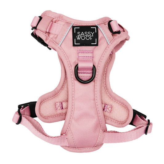 The Sassy Woof Dog Step-in Harness in Dusty Rose features adjustable straps, sturdy black buckles, a metal leash ring, and a black patch with the brand name in white letters.