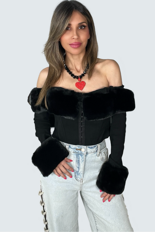 Black off the shoulder top with faux fur trim along the neckline and cuffs, full sleeves, and corset-inspired seaming.