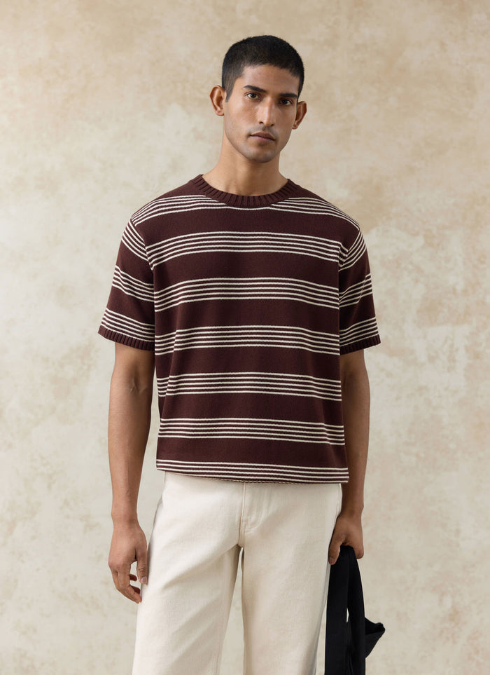 The Percival Fiction Striped Knitted T Shirt in espresso brown cotton with ecru stripes, worn with cream trousers.