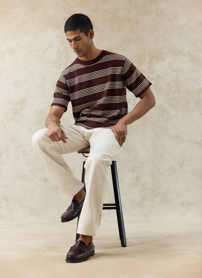Espresso brown Percival Fiction striped knitted cotton T-shirt with ecru stripes, styled with cream trousers on a model.