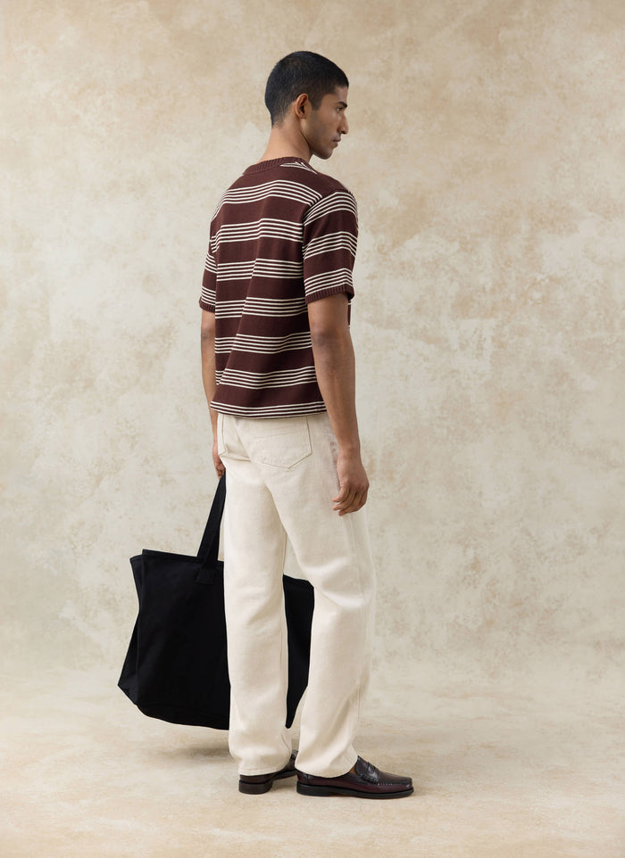 Espresso brown Percival Fiction striped knitted T-shirt, styled from behind with cream jeans and a black tote bag.