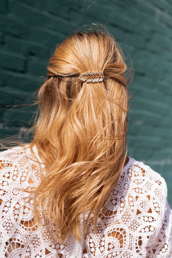 Golden Cannes feather hairclip worn in hair