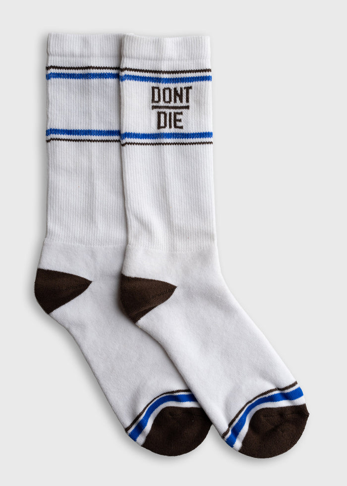 White socks with brown toes and heels, blue stripes, and "DON'T DIE" text. Simple design on a plain background.
