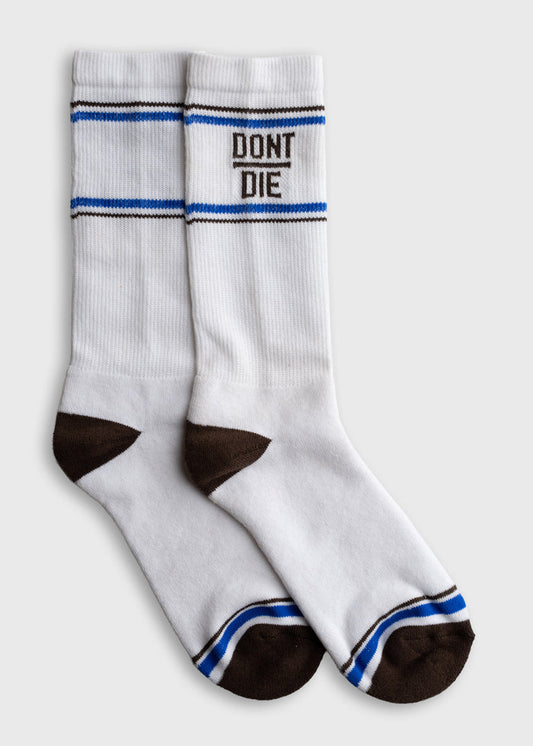 White socks with brown toes and heels, blue stripes, and "DON'T DIE" text. Simple design on a plain background.