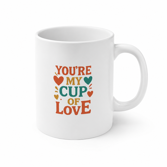 Romantic coffee mug with a heart shaped handle, glossy white ceramic body and bright artwork for Valentine's Day gift giving.