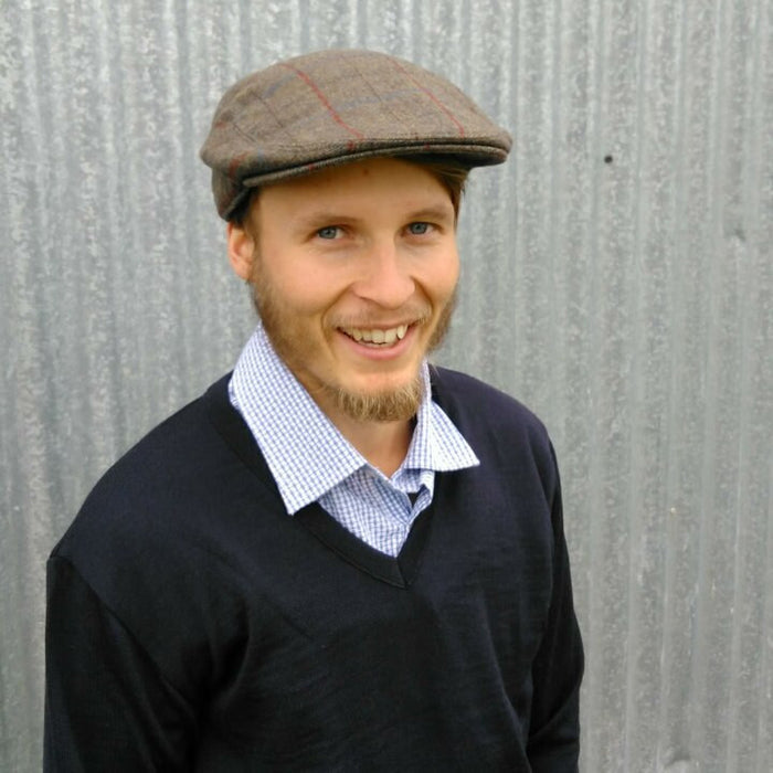 Man wearing Bingley Check Lambswool Tweed Cheesecutter hat in olive colour.