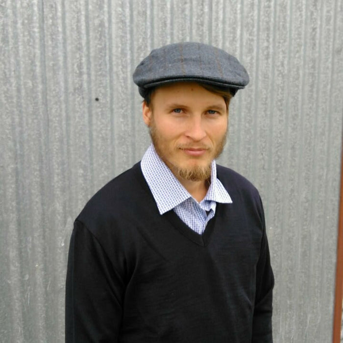 Man wearing blue coloured checkered plaid design, Cheesecutter hat.