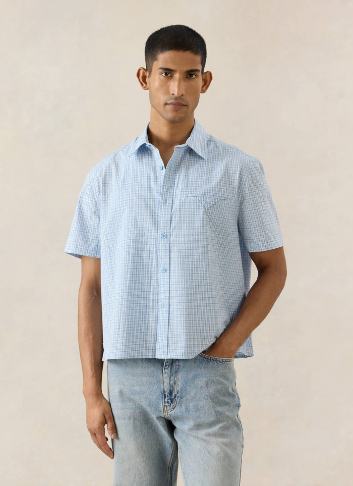 Blue check cotton Percival Hinsley Boxy Short Sleeve Shirt with a unique pocket detail, styled with light wash jeans.