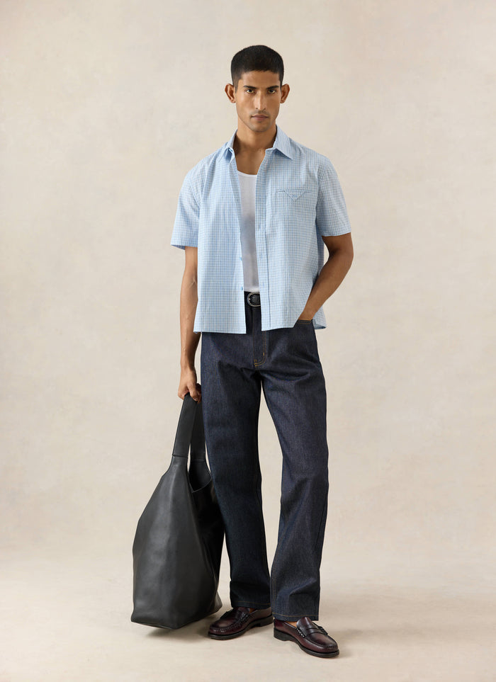 Percival blue check Hinsley short sleeve shirt with pocket detail, styled with structured Heritage jeans and a bag.