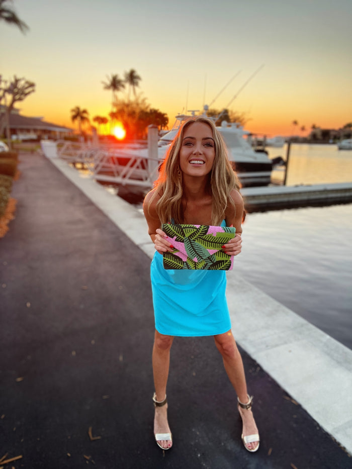 Model with tropical leaf purse wearing Jude Connally Bailey Dress in Santorini Blue