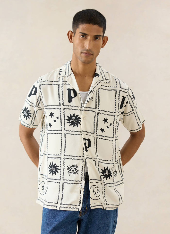 Percival Lunar Panel Cuban Shirt in cream viscose, featuring black celestial graphic panels, worn by a model.