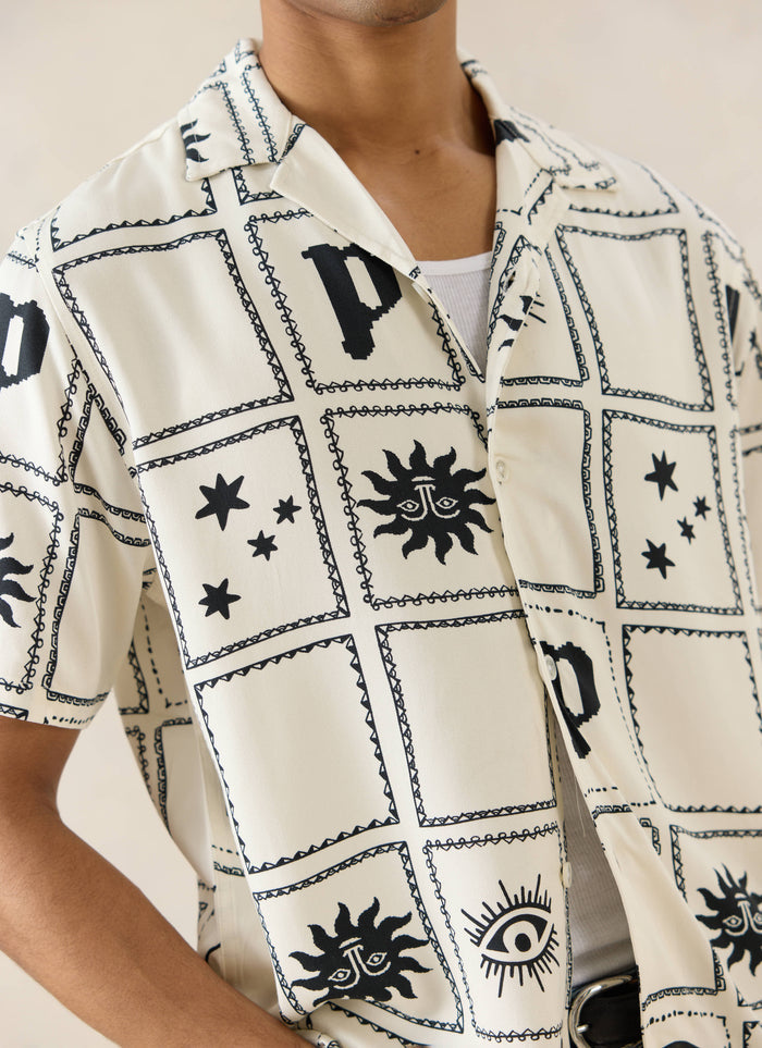 Percival Lunar Panel Cuban Shirt in cream viscose, featuring a black celestial panel print with stars, suns, and eyes.
