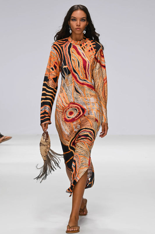 Model walking on a runway wearing a Aboriginal artwork dress.