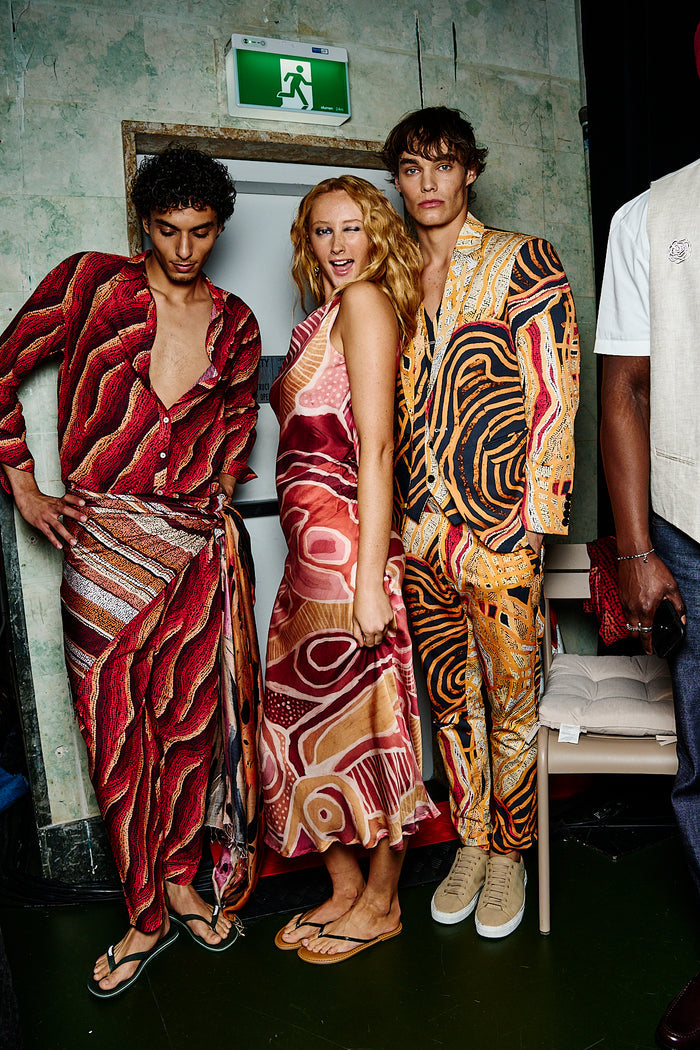 Three models in First Nations designed clothing