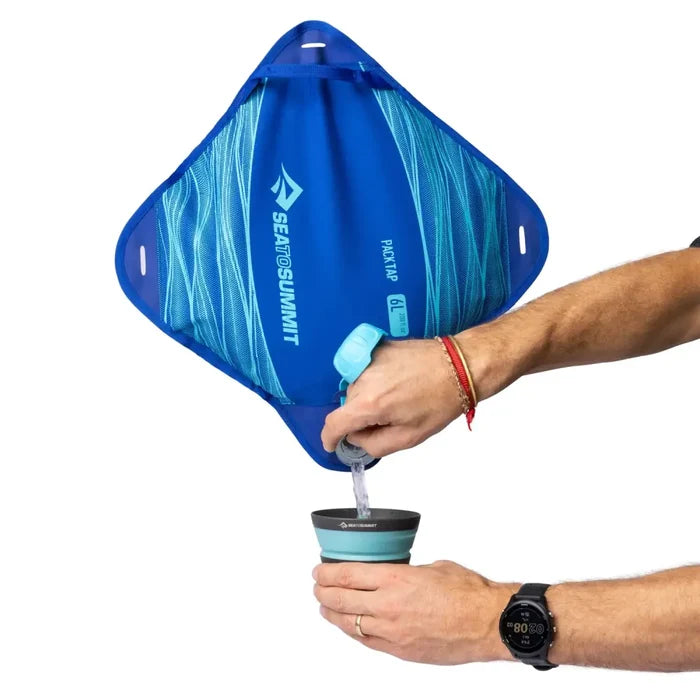 Person dispensing water into a collapsible cup from a Sea To Summit Pack Tap 6 litre Water Carrier on a  white background