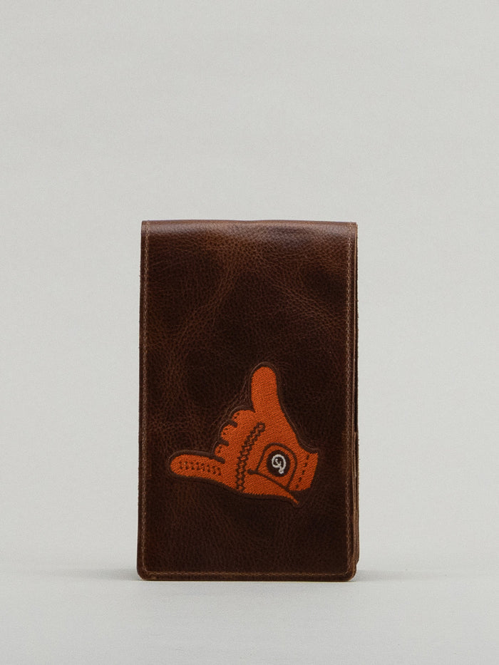 Brown leather yardage book with orange shaka glove embroidery