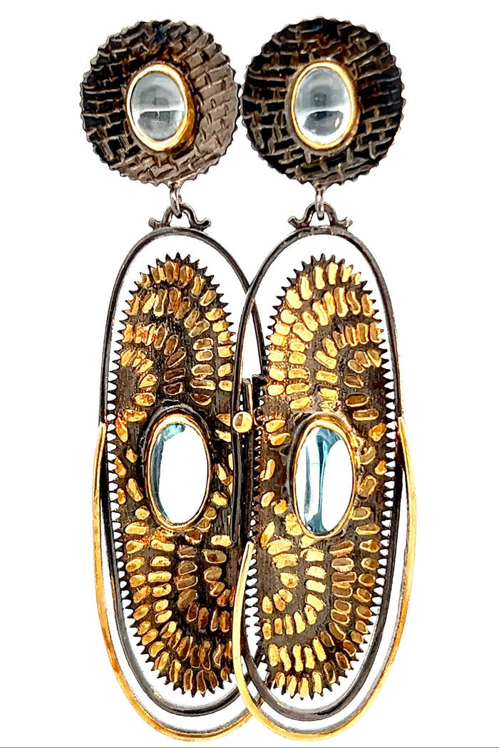 Sterling silver and gold aquamarine drop earring with a blue gemstone accent and artisan mixed metal oval frame.