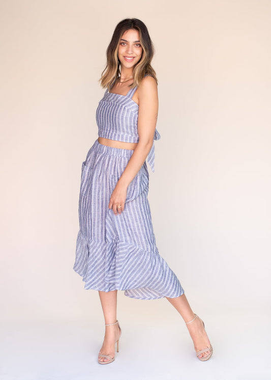 Woman wearing a blue striped outfit on a plain background