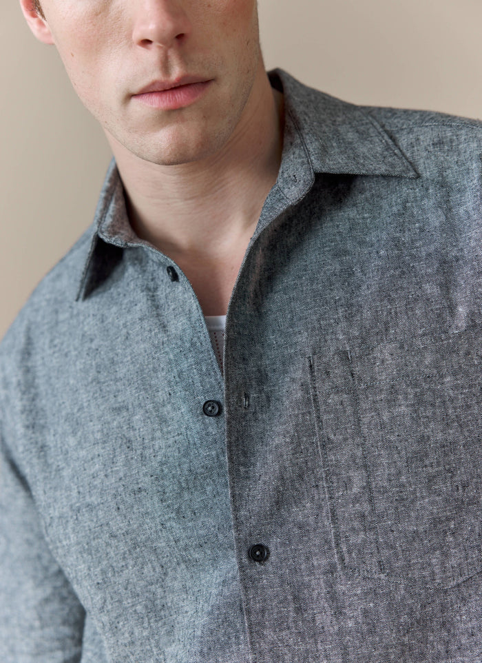A close-up of a model wearing the Percival Textured Boxy Shirt in grey, showing the detail of the cotton-linen fabric.