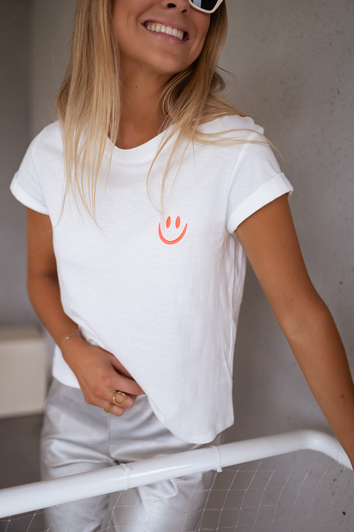 White Smiley graphic t-shirt with neon orange smiley, front view