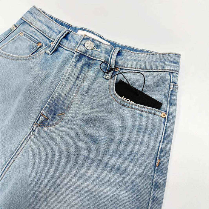 Blue jeans with a black phone case in the pocket on a white background