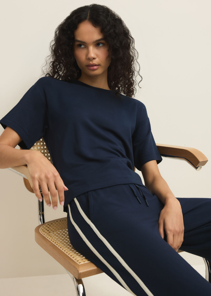 Woman wearing a navy short sleeve tee with navy pants
