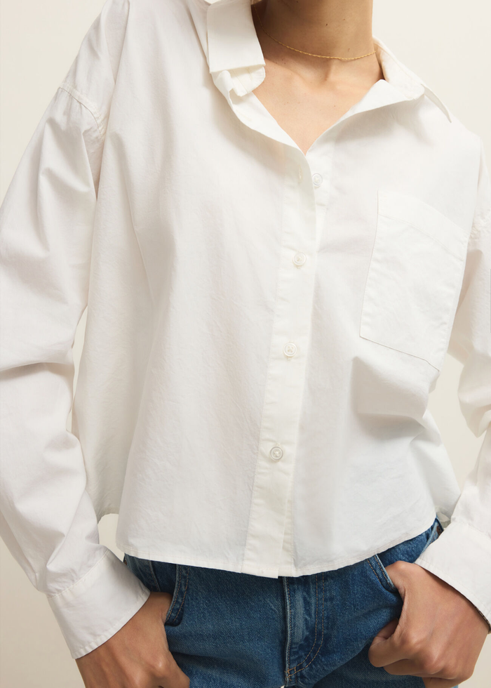 Woman wearing a white button down top with jeans